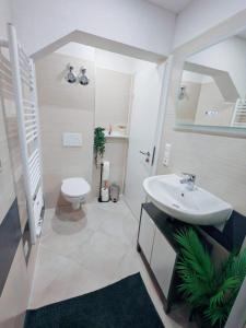 a white bathroom with a sink and a toilet at Stylvolles & schönes Apartment in Neuenstadt am Kocher