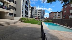 a swimming pool in front of a building at Dpto en Planta Baja Cba Cap con seguridad in Cordoba
