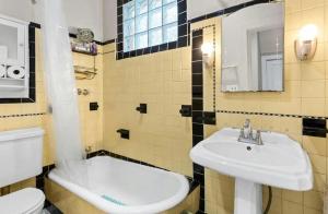 a bathroom with a sink and a toilet and a tub at Cathedral Hill Charm in Saint Paul