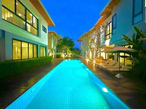a swimming pool in front of a building at night at Chic Villa 6 in Chiang Mai