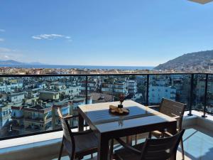 a table on a balcony with a view of a city at Luxury apartment with panoramic sea view ruby in Alanya