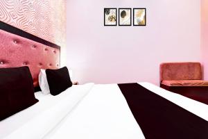 un dormitorio con una cama y una silla en Hotel O S B Guest house, en Varanasi