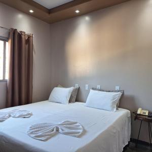 a bedroom with a bed with a bow on it at Pousada Sol do Araguaia in Barra do Garças +19 photos