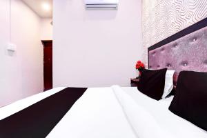 1 dormitorio con cama blanca y cabecero morado en Hotel O S B Guest house, en Varanasi 18 fotos más