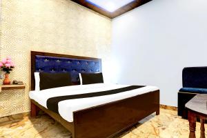 Un dormitorio con una cama con cabecero azul. en Hotel O S B Guest house, en Varanasi