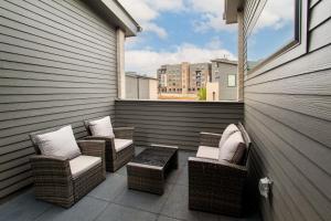 a patio with wicker chairs and a table on a balcony at Modern Cityscape Downtown Knoxville in Knoxville