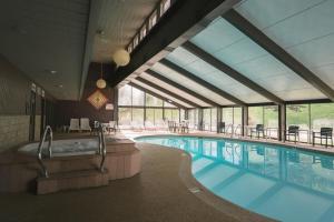 a large pool with a hot tub and tables and chairs at Town & Country Inn & Resort in Gorham