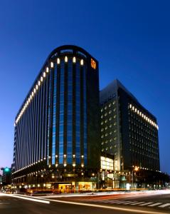 un grande edificio con luci di fronte a una strada di Tempus Hotel a Taichung