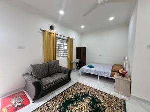 a living room with a couch and a bed at Capital O 91117 Noor Room Stay in Taiping