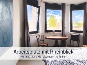 a table and chairs in a room with windows at Rheinblick7 Neuss - Spektakulärer Blick auf die Düsseldorfer Skyline - Ruhig Modern Privatparkplatz Aufzug - Top Anbindung an Messe Flughafen Hauptbahnhof in Neuss