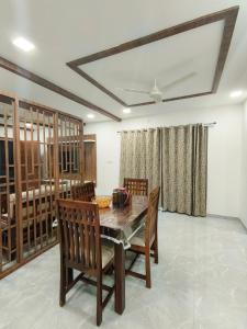 a dining room with a wooden table and chairs at Ultra-Modern Fullt Furnished 2BHK Near JNTU Metro - Launched Just Now in Hyderabad +16 photos