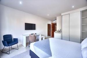 a bedroom with a bed and a desk and a tv at Cam's Suites in Santa Maria