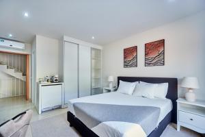 a bedroom with a large bed and a staircase at Cam's Suites in Santa Maria