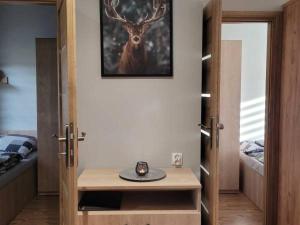 una stanza con un tavolo con la foto di un cervo sul muro di Domki Magiczne Miejsce a Hużele