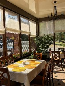 a dining room with a table and chairs and windows at Vila Luminita in Sângeorz-Băi