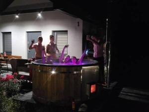 Un gruppo di uomini intorno a una vasca idromassaggio di Domki Magiczne Miejsce a Hużele
