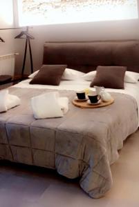 a bed with two cups and a tray on it at Molino nuovo in Maslianico