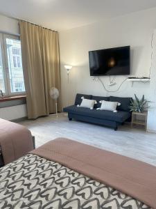 a living room with a blue couch and a flat screen tv at Exclusive Apartments Smolna in Warsaw