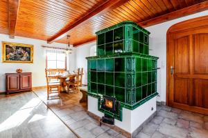 a green fireplace in a living room with a table at Ubytování Halámky 38 in Halámky