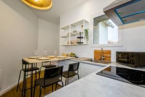 una cucina con bancone e sedie di La Résidence - Louez l'un de nos 4 appartements privés ! a Cholet