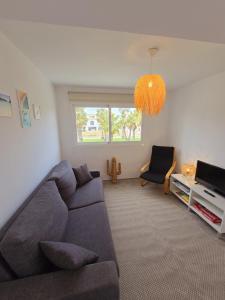 a living room with a couch and a television at Cozy apartment - Beach 100m away in Sa Caleta