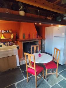 a kitchen with a table and two chairs and a fireplace at La Casita de Sandra in Paulenca