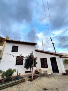a white house with a table and chairs in front of it at La Casita de Sandra in Paulenca