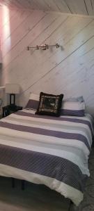 a bed in a room with a wooden wall at Greer Point Trails End Cabins in Greer