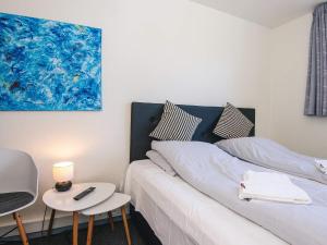a bedroom with two beds and a table and a painting at Splendid cabin in camping resort in Aabenraa +29 photos