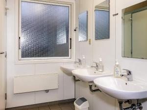 a bathroom with two sinks and two mirrors at 4 person friendly stay in Læsø in Læsø