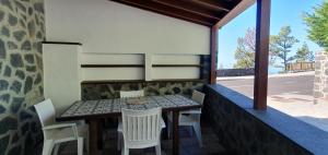 a table and chairs on the balcony of a house at La Casa de Iya in Las Indias