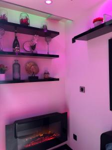 a living room with pink lighting and a fireplace at C12 Deluxe in Cap d'Agde