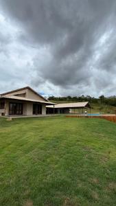 a large building with a large green field in front of it at Village Casa Grande in Paraopeba