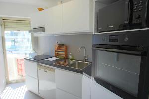 a kitchen with a sink and a microwave at AMAZING SEA VIEW APARTMENT in Cannes
