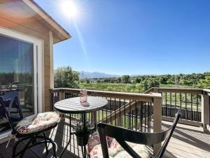 Un patio con una mesa y sillas en un balcón. en Trailside Getaway - mins to Ft Carson & Airport, en Fountain
