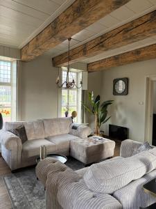 un salon avec deux canapés et une table dans l'établissement B&B Het Molenhuisje Winschoten - met woonkamer & keuken, à Winschoten