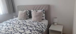 a bed with blue and white sheets and pillows at Nela Bl in Banja Luka