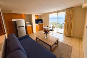 a living room with a blue couch and a kitchen at Ocean view & direct beach access! in Puerto Vallarta