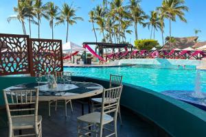 a table and chairs next to a swimming pool at Ocean view & direct beach access! in Puerto Vallarta