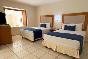 Una habitación de hotel con dos camas y un televisor. en Ocean view & direct beach access!, en Puerto Vallarta 28 fotos más
