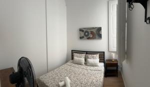 a bedroom with a bed with white walls and a window at Yellow Guesthouse in Faro