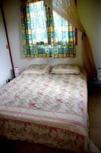 a bedroom with a bed and a window with curtains at Charmante maison à Sainte-Anne avec jardin in Sainte-Anne