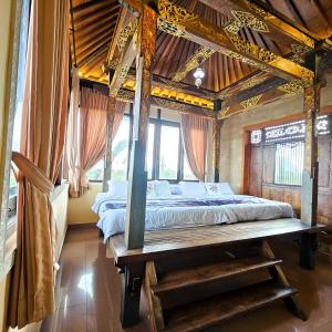 a bedroom with a bed with a wooden ceiling at Villa Djojonagoro in Ketewel