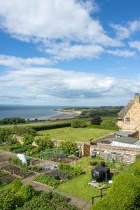 an aerial view of a farm with the ocean in the background at Whatton Cottage in Gullane