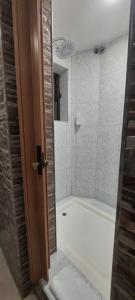 a bathroom with a white tub and a shower at Residencial Sol da Nave in Porto
