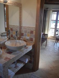 baño con lavabo y espejo grande en Monte Atena B&B di Charme, en Stintino