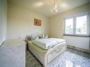 a bedroom with a white bed and a window at Ferienhaus an der Wiese, Tanne in Tanne +10 photos
