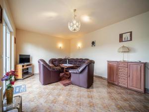 a living room with couches and a table and a tv at Ferienhaus an der Wiese, Tanne in Tanne