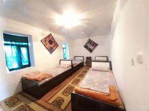 a room with two beds and a window at Sentyab Obi chashma guest house in Tadzhimi +74 photos