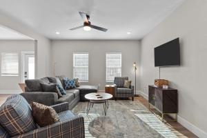 a living room with a couch and a flat screen tv at 3325 Bright Urban Comfort in Tower Grove